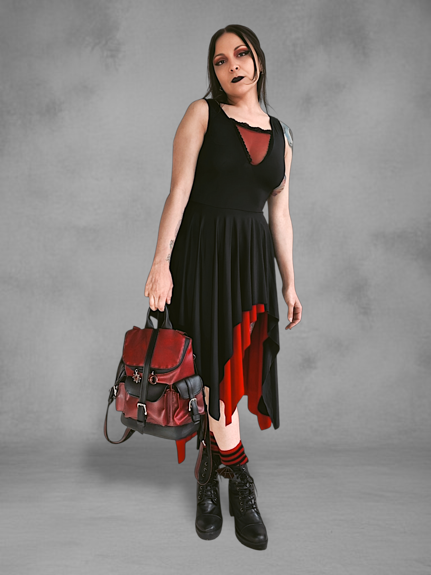 Mochila gotica de cuerina rojo borgona y negro en las manos de una modelo