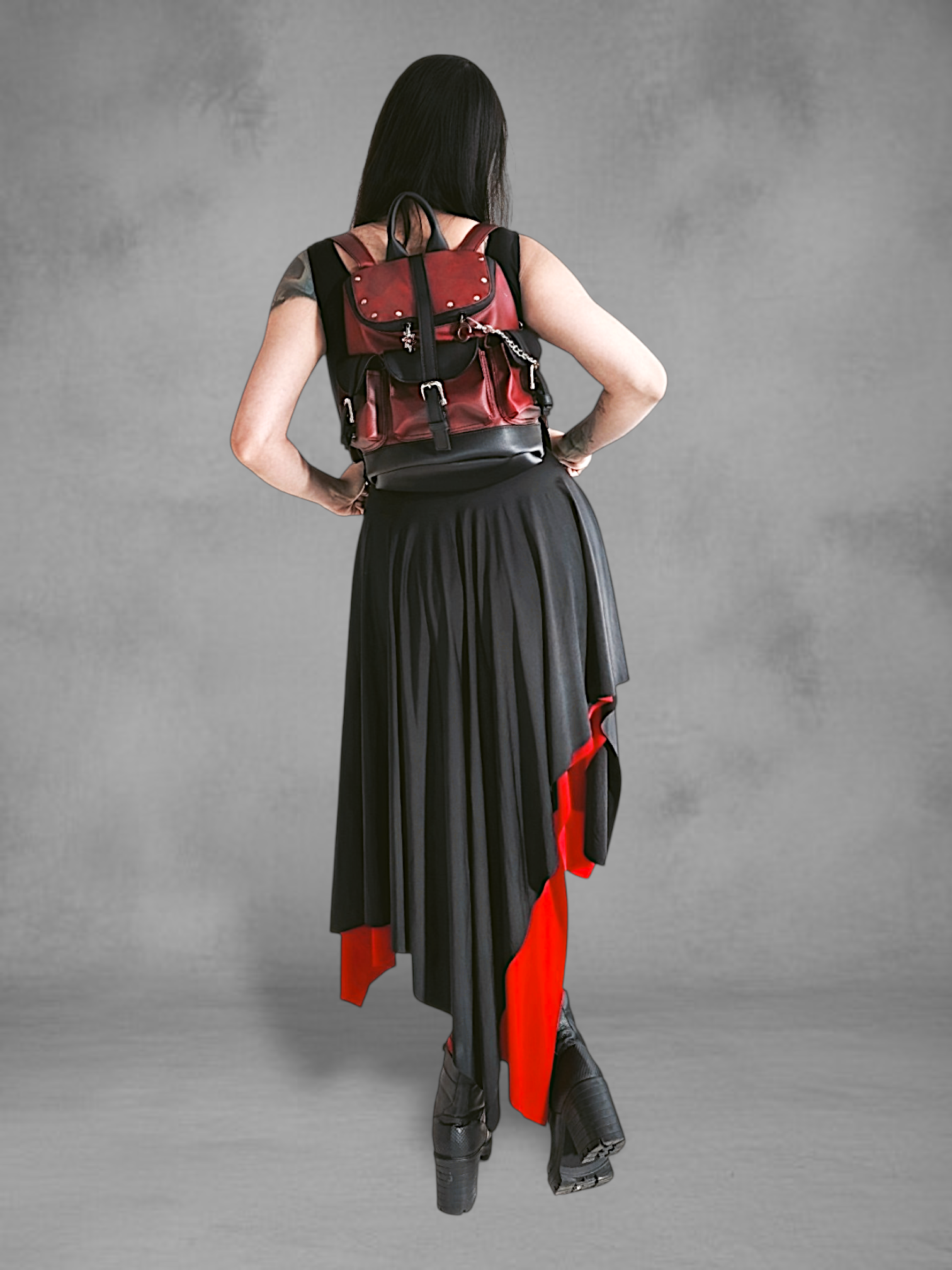 Mochila gotica de cuerina rojo borgona y negro en las manos de una modelo